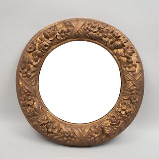 Espejo. Siglo XX. Elaborado en madera dorada. Con luna circular. Decorado con elementos vegetales, florales, lacería. 50 x 5 cm Ø