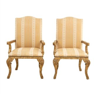 Par de sillones. Siglo XX. En talla de madera dorada. Con respaldos cerrados y asientos acojinados en tapicería rayada.