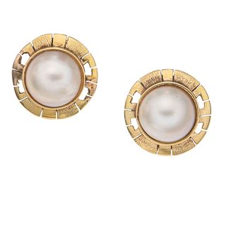 Par de aretes con medias perlas en oro amarillo de 10k. 2 medias perlas color gris de 11 mm. Peso: 6.3 g.