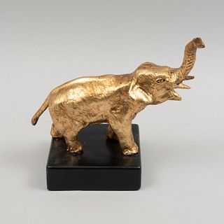 Figura de elefante. Siglo XX. Fundición en antimonio en esmalte dorado con base de madera ebonizada. 19 x 25 cm