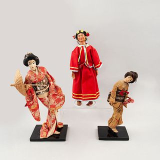 Lote de muñecas decorativas. Siglo XX. Una elaborada en cerámica policromada y textil. Con vestimentas tradicionales. Pz: 3