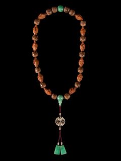 A Jadeite and Nut Bead NecklaceOverall length 19 in., 48.26 cm.