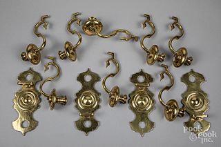Set of four brass double arm wall sconces.