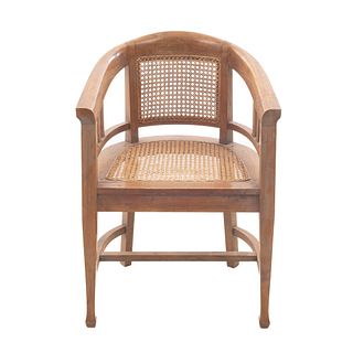 Sillón. Francia. Siglo XX. En talla de madera de nogal. Con respaldo y asiento de bejuco y fustes lisos.