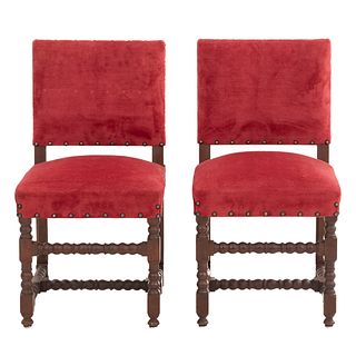 Par de sillas. Francia. Siglo XX. En talla de madera de roble. Con respaldos cerrados y asientos en tapicería color rojo.
