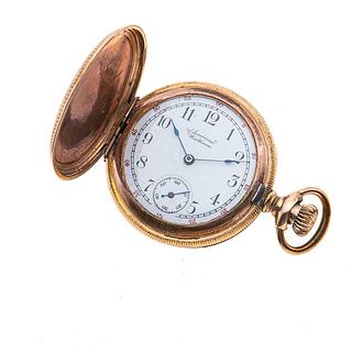 Reloj de bolsillo American Waltham. Movimiento manual. Caja circular en chapa. Carátula color blanco con índices de números arábigos.