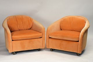 Pair of peach velvet lounge chairs on casters