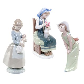 Lote de figuras decorativas. España, siglo XX. En porcelana Lladró y Nao: Niña con sombrero, niña sentada con flores. Piezas: 3
