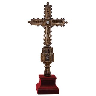 Cross. 18th century. Wood carved with remains of gilding on a square base.
