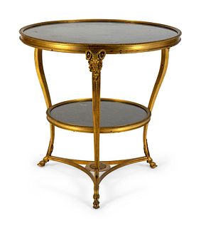 A Gilt Bronze Two-Tier Gueridon with Inset Black Marble Top and Shelf
Height 27 x diameter 21 inches.