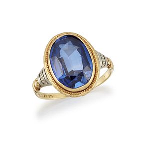 A SYNTHETIC SAPPHIRE RING
 The collet-set oval-cut