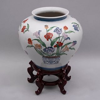Jarrón. China, siglo XX. Elaborado en cerámica policromada con base de madera laqueada. Decorado con motivos florales.