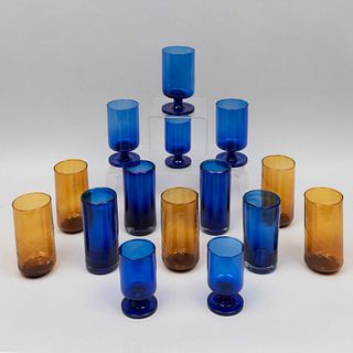 Lote de 18 vasos y copas. Siglo XX. En vidrio soplado. Colores azul y ámbar. Diferentes tamaños. Consta de: 8 vasos y 10 copas.