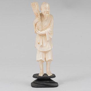 Hombre del campo. Origen oriental. Siglo XX. Elaborado en talla de marfil con base de madera. 13 cm (alto).