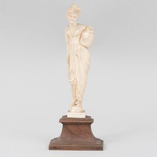 Dama con cántaro. Origen oriental. Siglo XX. Elaborado en talla de marfil con base de madera. 17.5 cm (alto).