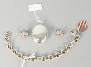 Four piece lot of Tiffany and Company sterling silver jewelry to include oval locket, link bracelet with oval charm applied with enamel in American fl