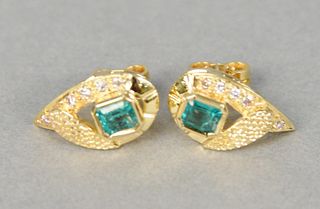 Pair of gold, emerald, and diamond earrings centering two emeralds, approximately 1.50 carats accented by diamonds, approximately .10 carats.
