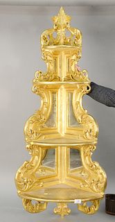 Gilded hanging corner shelf having four tiers and a mirrored back, ht. 55", wd. 22".