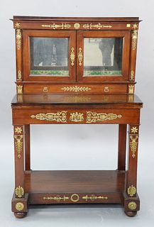 Regency style writing desk having glass door top flanked by brass bust mounts over flip writing surface over one drawer, brass mounts throughout, ht. 