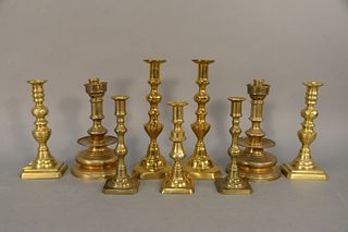 Group of nine brass candlesticks, two pairs of 19th C. push-up and five others, tallest 12". Estate of Marilyn Ware Strasburg, PA.