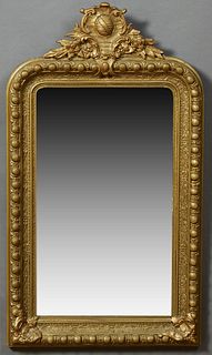 French Gilt and Gesso Overmantel Mirror, 19th c., with an arched shield and floral crest over a rounded corner frame with a large be...