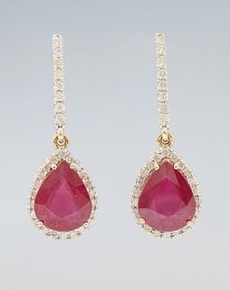 Pair of 14K Yellow Gold Pendant Earrings, each with a rigid diamond mounted link to a pear shaped pendant, with a pear shaped ruby a...