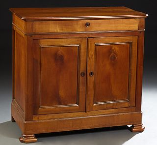 French Louis Philippe Carved Cherry Sideboard, late 19th c., the stepped canted corner top over a frieze drawer and double cupboard...