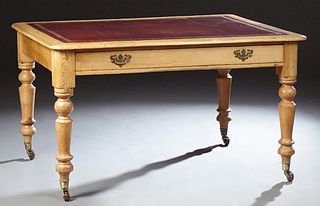 English Carved Pine Writing Table, 19th c., the rounded edge and corner top with an inset gilt tooled leather top, over a long friez...