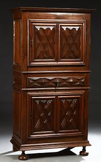French Provincial Louis XIII Style Carved Walnut Homme Debout, 19th c., the stepped crown over a single cupboard door with iron fich...