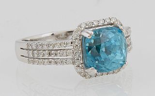 Lady's 14K White Gold Dinner Ring, with a cushion cut 4.8 carat blue zircon, atop a border of tiny round diamonds, the triple split...