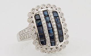 Lady's 14K White Gold Dinner Ring, the arched top with three parallel bands of princess cut blue sapphires, separated by diamond mou...