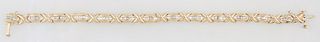 14K Yellow Gold Link Bracelet, each of the 12 arched oval links with a center row of 5 graduated channel set baguette diamonds, join...