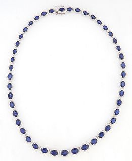 14K White Gold Link Necklace, each of the 45 oval links with a graduated oval blue sapphire, atop a border of round diamonds, total...