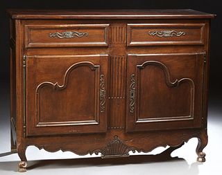 French Provincial Louis XV Style Carved Walnut Sideboard, 19th c., the canted corner top over two frieze drawers above double cupboa...
