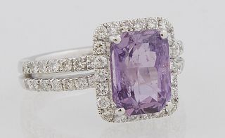 Lady's Platinum Dinner Ring, with an emerald cut 4.23 carat purple sapphire, atop a border of round diamonds, the split shoulders of...