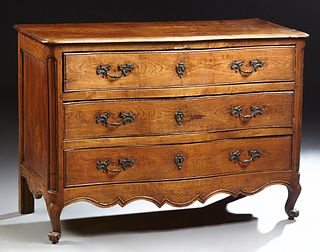 French Provincial Louis XV Style Carved Oak, Walnut and Cherry Bowfront Commode, early 19th c., the bowed top over three bowed drawe...