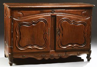 French Provincial Louis XIV Style Carved Walnut Sideboard, 18th c., the rounded corner and edge three board top over a central friez...