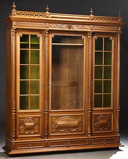Exceptional French Henri II Style Carved Walnut Bookcase, c. 1880, the pierced finialed crown over a setback center door with a glaz...