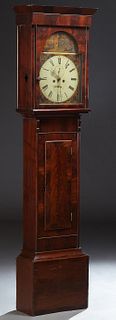 English Carved Mahogany Tall Case Clock, 19th c., the canted crown over a glazed door enclosing an arched hand painted dial with sec...