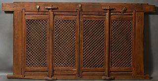 Chinese Carved Elm Window Screen, early 20th c., with four hinged pierced x-form doors, H.- 52 1/2 in., W.- 102 in., D.- 4 in.