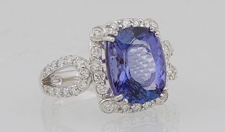 Lady's Platinum Dinner Ring with a 4.55 carat cushion cut tanzanite, atop a border of round diamonds, the split pierced shoulders of...