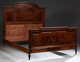 French Louis XVI Style Carved Mahogany Double Bed, c. 1900, with an arched headboard to carved rails and a footboard with a carved o...