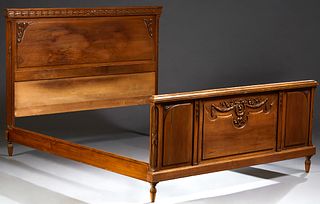 French Carved Walnut Louis XV Style Double Bed, 20th c., the head board with a relief leaf and berry frieze over an arched fielded p...