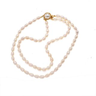 Gargantilla de perlas y metal base dorado. Diseño de dos hilos con 74 perlas cultivadas. Broche metal base dorado. Peso: 46.1 g.