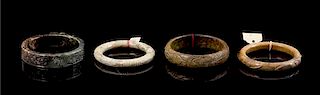 * A Group of Four Hardstone Bangles Diameter of largest 3 1/2 inches.