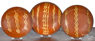 Three Pennsylvania slip decorated redware plates