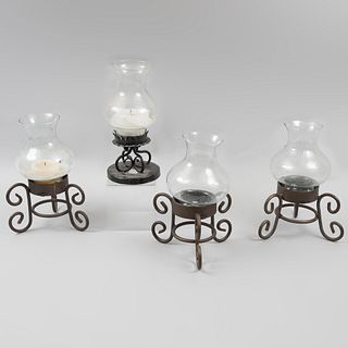 Lot of 4 candle holders. Twentieth century. Made of wrought iron and sheet. With glass screens and roll-type supports.