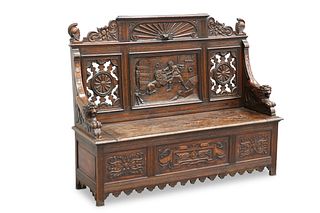 A LATE 19TH CENTURY CARVED OAK SETTLE, the crest 