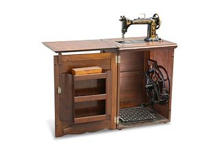 A CABINET TREADLE SEWING MACHINE BY WHEELER & WIL