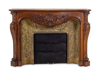 A Louis XV Style Carved Walnut and Pressed Gilt Metal Fireplace